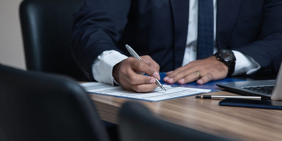 A man signing legal documents in a law office.