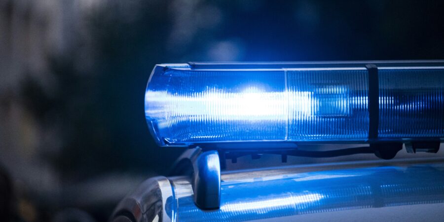 A close up view of a police car's emergency lights activated with a dark background, indicating an emergency response.