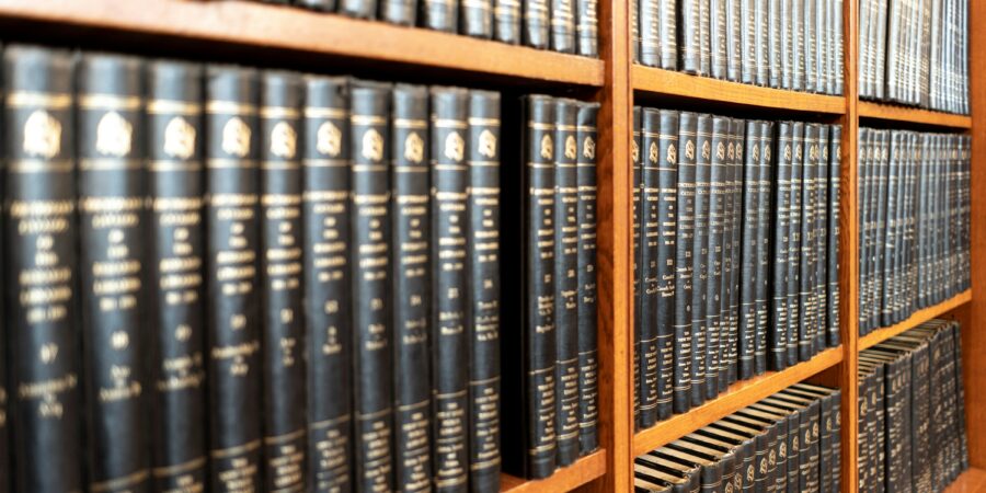 A close-up of a bookshelf filled with books for law research, mostly in black bindings.