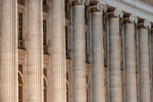 A close-up of a government or institutional building with classical architecture facade with rows of tall, stone columns.