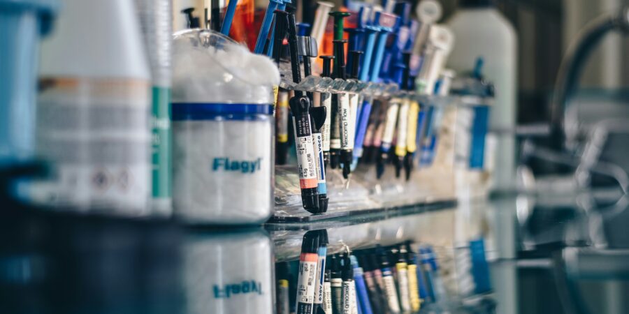 A shelf filled with various laboratory vials and equipment, including syringes and bottles.